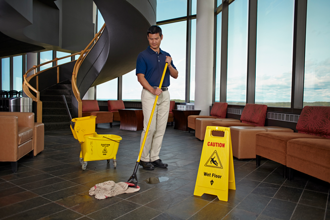 A staff mopping the floor with Rubbermaid Microfibre Mop